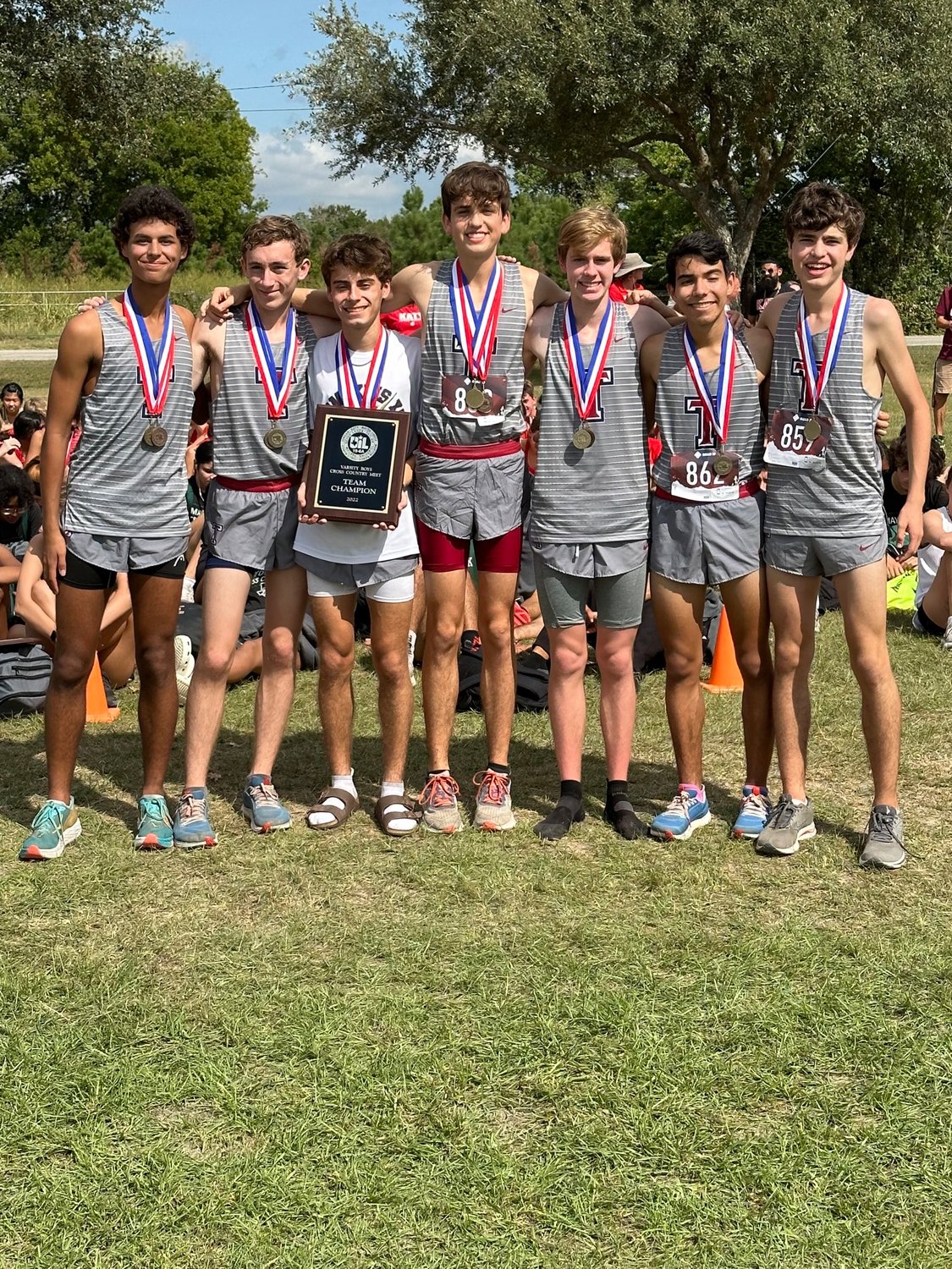 The Tompkins boys cross country team celebrates winning the District 19-6A cross country meet on Thursday morning at Paul D. Rushing Park.